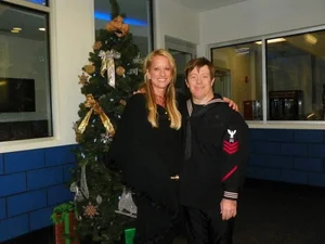 Tracey with a sailor in dress uniform at a holiday event.