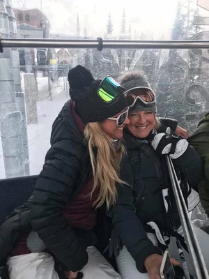 Tracey in ski gear riding a mountain gondola.